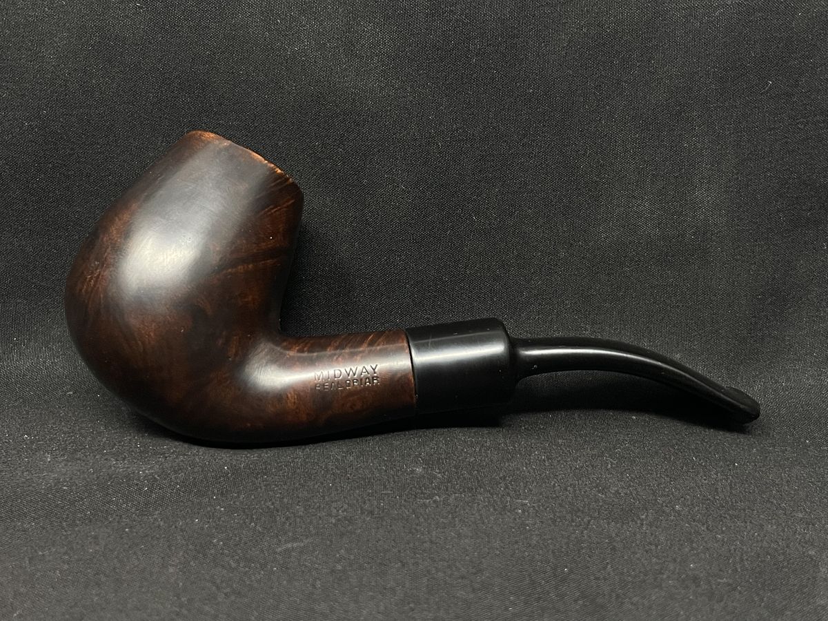 Dark bent briar pipe on charcoal cloth